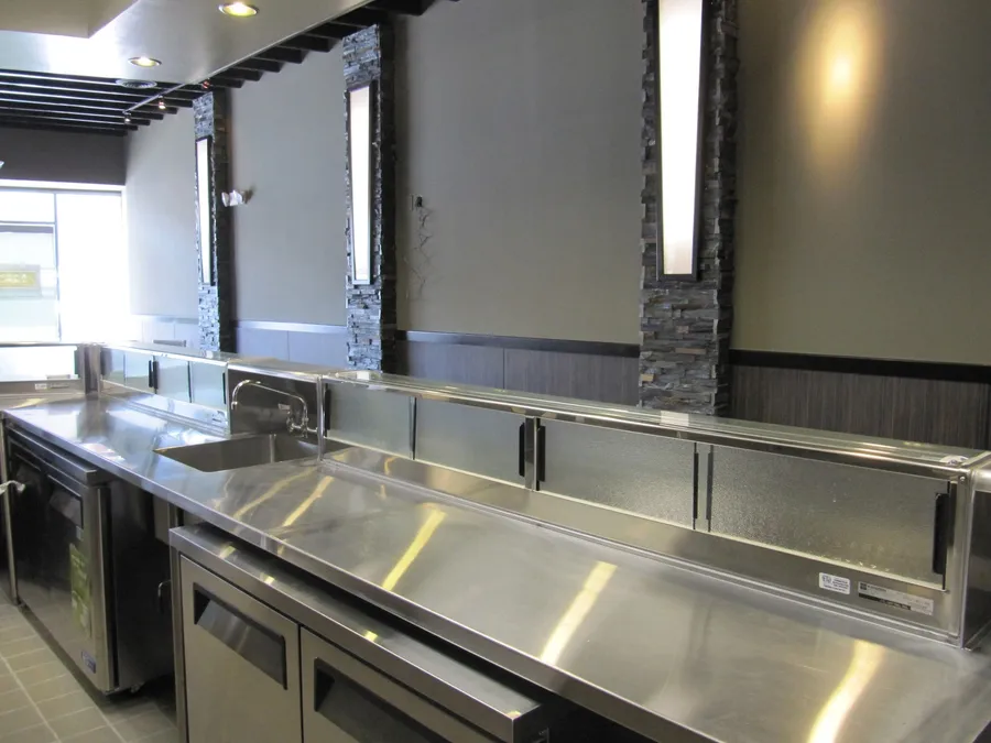 Custom stainless steel sushi prep table installed in a restaurant kitchen